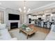 Open-concept living space with fireplace, modern kitchen and spacious seating with pendant lights at 95 Great Smoky Pl, Lillington, NC 27546