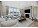Bright living room with large windows, fireplace, neutral furniture, and a cozy atmosphere at 95 Great Smoky Pl, Lillington, NC 27546