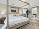 Cozy main bedroom showcasing a stylish bed, hardwood floors, and an open ensuite bathroom at 95 Great Smoky Pl, Lillington, NC 27546