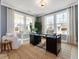 Bright office features a black desk, large windows, wood floors, and comfortable seating area at 95 Great Smoky Pl, Lillington, NC 27546