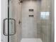 Modern tiled walk-in shower featuring glass door and built-in shelves at 95 Great Smoky Pl, Lillington, NC 27546