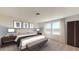 Serene bedroom with two large windows, neutral walls, carpeted floors, and modern furniture at 1157 Solace Way, Rolesville, NC 27571