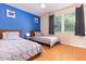 Bright bedroom featuring two twin beds, hardwood floors, and a blue accent wall at 124 Friar Ln, Carrboro, NC 27510