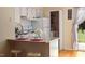 Efficient kitchen featuring a breakfast bar, white appliances, and a view of the yard at 124 Friar Ln, Carrboro, NC 27510