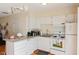 Well-lit kitchen featuring granite countertops, white cabinets, and modern appliances at 124 Friar Ln, Carrboro, NC 27510