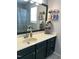 Modern bathroom with light countertops, dark blue cabinets, a large mirror, and transparent toiletries holders at 128 Madeline Ct, Youngsville, NC 27596