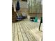 Wooden back deck with a fire pit, a set of stairs, chairs, and a view of the lush forest at 128 Madeline Ct, Youngsville, NC 27596