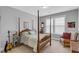Comfortable bedroom with a four-poster bed, guitar, and a cozy sitting area at 156 Greenhurst Cir, Holly Springs, NC 27540