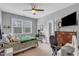 Cozy bedroom features a ceiling fan, desk area, and dresser with a mounted television at 156 Greenhurst Cir, Holly Springs, NC 27540