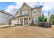 Lovely two-story home with stone accents, an attached garage, and mature landscaping at 156 Greenhurst Cir, Holly Springs, NC 27540