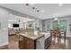 Open-concept kitchen features an island with a sink, granite countertops, and pendant lighting at 156 Greenhurst Cir, Holly Springs, NC 27540