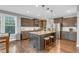 Modern kitchen with granite counters, stainless steel appliances, and a central island with seating at 156 Greenhurst Cir, Holly Springs, NC 27540