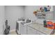 Well-organized laundry room with modern washer, dryer, shelving, and ample counter space at 156 Greenhurst Cir, Holly Springs, NC 27540