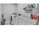 Well-lit laundry room with modern washer and dryer, storage cabinets and granite countertops at 156 Greenhurst Cir, Holly Springs, NC 27540