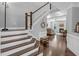 Elegant staircase leading to a cozy living room with a fireplace and hardwood floors at 156 Greenhurst Cir, Holly Springs, NC 27540