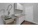 Functional utility sink with a stainless steel basin, white cabinetry, and granite countertops at 156 Greenhurst Cir, Holly Springs, NC 27540