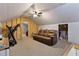 Attic featuring exposed beams, a ceiling fan and a brown leather couch at 166 Creek Dr, Louisburg, NC 27549