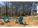 Landscaped backyard area featuring outdoor seating, a gravel area, and trees at 166 Creek Dr, Louisburg, NC 27549