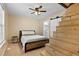 A bedroom with a wooden bed frame, a ceiling fan and a set of wooden stairs at 166 Creek Dr, Louisburg, NC 27549