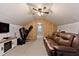 Large bonus room featuring a brown leather sofa and exercise equipment, offering space for relaxation and fitness at 166 Creek Dr, Louisburg, NC 27549