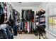 Organized walk-in closet featuring shelving, hanging racks, and natural light from window at 166 Creek Dr, Louisburg, NC 27549
