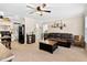 Open-concept living room with a leather couch connecting to the kitchen at 166 Creek Dr, Louisburg, NC 27549