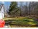 Large backyard featuring a lush lawn with mixed tree coverage, ideal for recreation and relaxation at 180 Normandy Rd, Louisburg, NC 27549