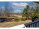 Scenic backyard view from the porch featuring lush greenery, mature trees, and a tranquil pond at 180 Normandy Rd, Louisburg, NC 27549