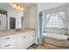 Bathroom with a vanity, mirror, and a large soaking tub with tile surround at 180 Normandy Rd, Louisburg, NC 27549