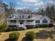 Charming single-story home featuring a large front porch, dormer windows, and mature landscaping at 180 Normandy Rd, Louisburg, NC 27549