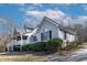 View of the side of this charming home, featuring light-colored siding and a covered porch, set against a blue sky at 180 Normandy Rd, Louisburg, NC 27549