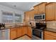 Kitchen with stainless appliances, granite countertops, tiled backsplash, and double sink near window at 180 Normandy Rd, Louisburg, NC 27549