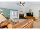 Spacious living room featuring a fireplace, ceiling fan, and plush seating, perfect for relaxation at 180 Normandy Rd, Louisburg, NC 27549