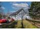 View of the back of the home with garage, vinyl siding and red car in the driveway at 180 Normandy Rd, Louisburg, NC 27549