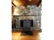 Stone fireplace featuring a raised hearth and wood burning stove insert in a rustic cabin-style living space at 182 Tree Cutters, Sanford, NC 27332