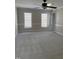 Spacious bedroom with neutral tones and a ceiling fan, illuminated by natural light from the large windows at 1904 Baronsmede Dr, Raleigh, NC 27615