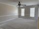 Large bedroom featuring plush carpeting, two windows, neutral color palette, and a ceiling fan at 1904 Baronsmede Dr, Raleigh, NC 27615