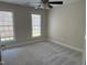 Airy bedroom with neutral decor, large windows, and a modern ceiling fan for added comfort at 1904 Baronsmede Dr, Raleigh, NC 27615