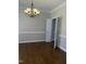 Spacious dining room with hardwood floors, elegant chandelier, and view into connecting room at 1904 Baronsmede Dr, Raleigh, NC 27615