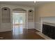 Elegant living room with built-in shelving, fireplace, hardwood floors, and access to rear patio at 1904 Baronsmede Dr, Raleigh, NC 27615