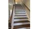 Staircase with hardwood steps and white risers, leading to the upper level of the home at 1904 Baronsmede Dr, Raleigh, NC 27615