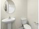 Cozy bathroom features pedestal sink, round mirror and classic toilet design at 209 Leven Dr, Gibsonville, NC 27249