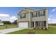 Charming two-story home with stone accents, a two-car garage, and a green lawn at 209 Leven Dr, Gibsonville, NC 27249