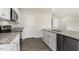 Modern kitchen featuring granite countertops, stainless steel appliances, and sleek white cabinetry at 209 Leven Dr, Gibsonville, NC 27249
