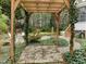 Backyard view with patio area, lush garden, pergola, and mature trees at 209 Plyersmill Rd, Cary, NC 27519