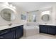 Spacious bathroom featuring double sinks, a soaking tub, and tiled floors at 209 Plyersmill Rd, Cary, NC 27519