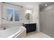 Bathroom featuring a shower, soaking tub, and vanity with navy blue cabinets at 209 Plyersmill Rd, Cary, NC 27519