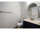 Updated bathroom featuring a large round mirror and vanity with dark wood cabinets at 209 Plyersmill Rd, Cary, NC 27519