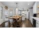 Bright kitchen features white cabinets, stainless steel appliances, butcher block island and a wooden dining table at 209 Plyersmill Rd, Cary, NC 27519