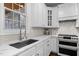 Bright kitchen features stainless steel appliances, marble counters, white cabinets and a window providing natural light at 209 Plyersmill Rd, Cary, NC 27519